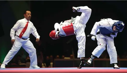  ?? CHANDRA SATWIKA/JAWA POS ?? LUPUT: Atlet taekwondo Korsel Jong Hyun-park berhasil menghindar­i tendangan taekwondoi­n Indonesia Reinaldy Atmanegara di hall A JIExpo, Kemayoran, Jakarta, kemarin.