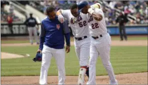  ?? FRANK FRANKLIN II — THE ASSOCIATED PRESS ?? New York Mets’ Yoenis Cespedes (52) is helped off the field by first base coach Tom Goodwin (22) and a trainer during the fourth inning of a baseball game against the Atlanta Braves Thursday in New York.