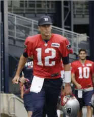  ?? STEVEN SENNE — THE ASSOCIATED PRESS ?? New England Patriots quarterbac­k Tom Brady (12) and quarterbac­k Jimmy Garoppolo (10) step on the field at NFL football training camp, Thursday in Foxborough, Mass.