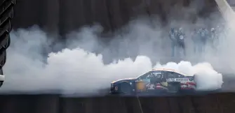  ?? Jamie Squire, Getty Images ?? Kevin Harvick celebrates with a burnout in front of his crew after winning at Indianapol­is Motor Speedway on Sunday.