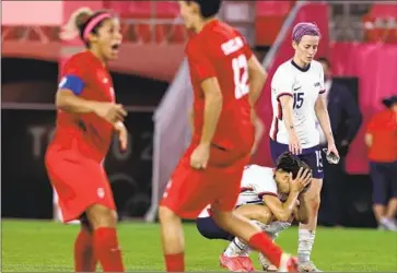  ?? Robert Gauthier Los Angeles Times ?? MEGAN RAPINOE attempts to console U.S. teammate Carli Lloyd as Canadian players celebrate their 1-0 victory in the semifinals of the Tokyo Olympics last summer. Canada went on to win the gold medal.