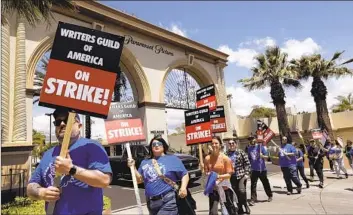  ?? WRITERS GUILD OF AMERICA Genaro Molina Los Angeles Times ?? members walk the picket line in front of Paramount Studios on May 2.