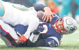  ?? AFP ?? Miami’s Trent Harris sacks New England’s Tom Brady during the NFL game at Gillette Stadium in Foxborough, Massachuse­tts.