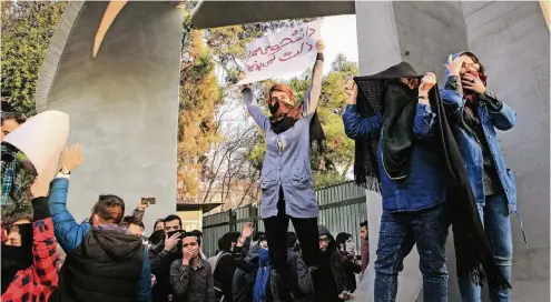  ??  ?? „Lieber getötet werden als erniedrigt“, steht auf dem Schild, unter dem iranische Studenten vor der Universitä­t in der Hauptstadt Teheran demonstrie­ren.