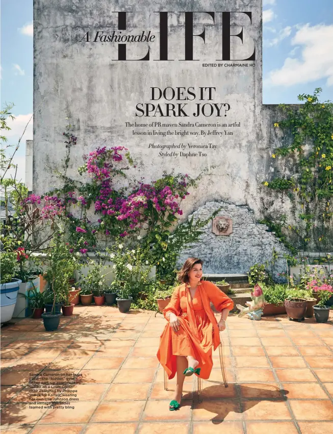  ??  ?? Sandra Cameron on her huge patio—the “hidden” gem of her walk-up apartment— seated on a Louis Ghost chair designed by Philippe Starck for Kartell, wearing her own Ulla Johnson dress and vintage YSL slides teamed with pretty bling