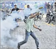  ??  ?? An anti-government protester throws a teargas cannister at police in the capital island Male on Wednesday. Several thousand supporters of former Maldives president Mohamed Nasheed clashed with police and troops in riot gear.