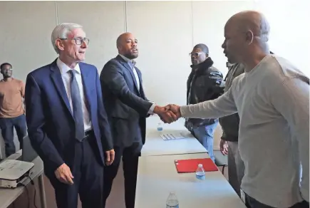  ?? MIKE DE SISTI / MILWAUKEE JOURNAL SENTINEL ?? Lt. Gov. Mandela Barnes shakes hands Monday with WRTP/Big Step participan­t Thadius Jones during an appearance with Gov. Tony Evers (left). Barnes and Evers toured WRTP/Big Step,t 3841 W. Wisconsin Ave.