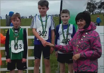  ??  ?? Harry Gough (left) from Cushinstow­n AC on the podium after finishing third in the Under-10 race at the Meath Junior, Novice and Even-Age Cross-Country Championsh­ips in Bohermeen on Sunday.