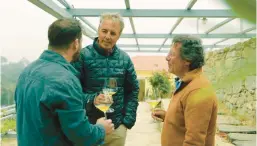  ?? NETFLIX ?? Dan Buettner, center, Afianes Wines founder Nikos Afianes, right, and his son Konstantin­os Afianes drink to their health in Greece in “Live to 100: Secrets of the Blue Zones.”