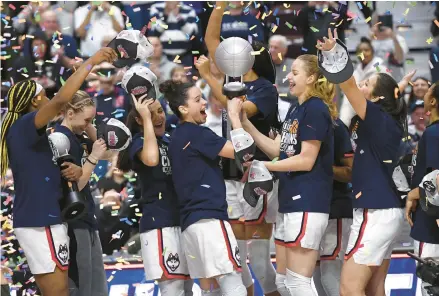  ?? JESSICA HILL/AP ?? UConn’s Lou Lopez Senechal, center left, and Dorka Juhasz, center right, hold the Big East Championsh­ip trophy as they celebrate with teammate after defeating Villanova in the finals of the Big East Conference tournament at Mohegan Sun Arena on Monday in Uncasville, Conn.