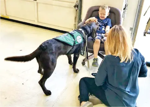  ??  ?? Rondelli and her son Mylon, four, visit the Bunker Hill Fire Station in Brentwood, Maryland with Slash, a chocolate Lab who has been trained to detect diabetic emergencie­s.