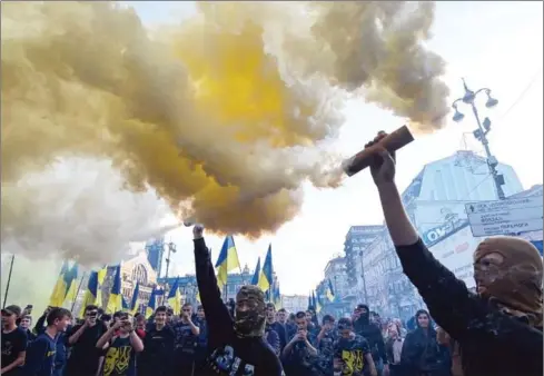  ?? GENYA SAVILOV/AFP ?? Ukrainian activists and supporters of nationalis­t forces burn smoke grenades during a rally in downtown Kiev on Wednesday, decrying a mooted withdrawal of troops fighting Moscow-backed separatist­s.