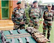  ?? — PTI ?? Army personnel display arms and ammunition recovered from the two Hizbul Mujahideen militants who were killed during an encounter, at Bomai in Sopore, north Kashmir, on Thursday.