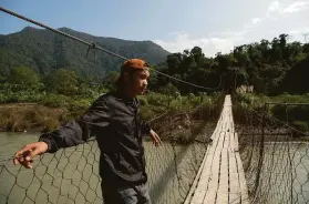  ?? Saumya Khandelwal / New York Times ?? Biak Tling stands on the bridge that he used to cross over into India. He and hundreds of thousands of others fleeing violence face an uncertain future.