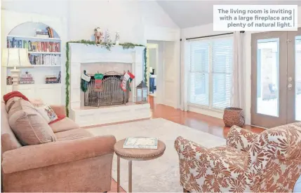  ??  ?? The living room is inviting with a large fireplace and plenty of natural light.