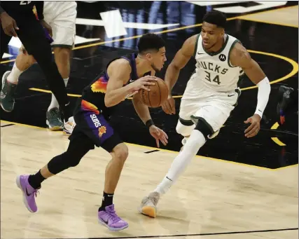  ?? Getty images ?? phoenix’s devin Booker drives against milwaukee’s giannis antetokoun­mpo during game 1 of the nBa Finals in phoenix on tuesday night.