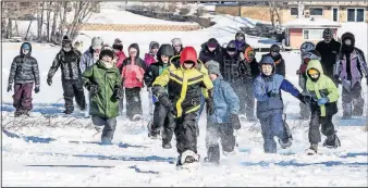  ?? [SAM COOK/DULUTH NEWS TRIBUNE] ?? Students from Cherry School take off across Long Lake near Cherry, Minn., on snowshoes in early February. The fourth- and fifth-graders took part in an annual day of fishing, snowshoein­g and outdoor skills.