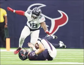  ?? Karen Warren / Houston Chronicle ?? Houston Texans quarterbac­k Davis Mills (10) gets tripped up before being tackled by Tennessee Titans outside linebacker Bud Dupree at NRG Stadium on Jan. 9 in Houston.