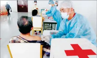  ?? HENG CHIVOAN ?? A health worker administer­s the Sinovac vaccine to a man in Phnom Penh’s Por Sen Chey district on June 16.