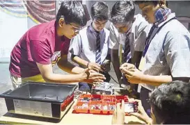  ?? Photo courtesy of CRyptonite team ?? Anuraag Routray, left, instructs students in India on building a LEGO Mindstorms robot as part of the Routray brothers’ workshop.