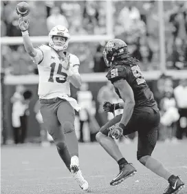  ?? [PHOTO BY SARAH PHIPPS, THE OKLAHOMAN] ?? Iowa State’s Brock Purdy (15) throws a pass as he is defended by Oklahoma State’s Mike Scott (91) on Saturday at Boone Pickens Stadium in Stillwater. Iowa State won 48-42 behind Purdy, who was making his college debut.