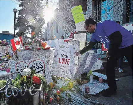  ?? FRANK GUNN THE CANADIAN PRESS ?? A man places a placard before a vigil rememberin­g the victims of the deadly van attack, at Mel Lastman Square in Toronto on Sunday.