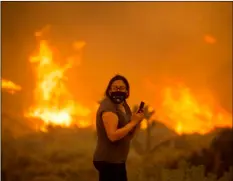  ?? AP PHOTO/RINGO H.W. CHIU ?? A woman watches as the Bobcat Fire burns in Juniper Hill, Calif., Friday.