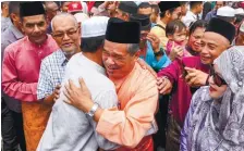  ??  ?? Mohamad Sabu being hugged by a guest at a Hari Raya Aidilfitri gathering at the Rural Transforma­tion Centre in Tanjong yesterday.