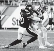  ?? Justin Berl / Getty Images ?? Bengals quarterbac­k Andy Dalton is pulled down by the Steelers’ T.J. Watt — one of eight sacks of Dalton.