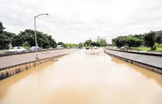  ?? Cody Duty / Houston Chronicle ?? Many roads remained under water Wednesday, including Allen Parkway at Montrose Boulevard.