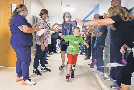  ?? KIRTHMON F. DOZIER/ USA TODAY NETWORK ?? Staff at Mary Free Bed Rehabilita­tion Hospital in Grand Rapids, Mich., clap as Waylon Wehrle, 7, heads home Aug. 10. Waylon had COVID- 19 in the spring and developed life- threatenin­g complicati­ons.