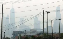  ?? PEREZ/ CHICAGO TRIBUNE ANTONIO ?? Chicago skyline and power lines along Halsted Street near Chicago Ave., during the second straight day of hazy and poor air quality conditions in Chicago on June 28, 2023.