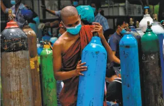  ?? Associated Press ?? A Buddhist monk joins others waiting to refill oxygen tanks at a plant in Yangon. Amid political strife, Myanmar is also struggling with a growing COVID19 outbreak.