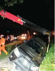  ?? FAJAR TUMANGGOR/JAWA POS ?? HANYA KORBAN LUKA: Dinas PMK mengevakua­si mobil Toyota Fortuner nopol L 1722 DR yang terperosok di MERR depan Universita­s Katolik Darma Cendika.