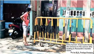  ??  ?? Entry barred: A barricade blocks the entrance to the narrow alley leading to Ruwanthi’s humble home.
Pic by M.A. Pushpa Kumara