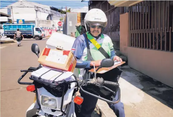  ?? ALBERT MARÍN. ?? El tradiciona­l cartero se reconvirti­ó y hoy presta servicios de diversos tipos, conectados mediante los teléfonos y otros dispositiv­os. En San Isidro de Heredia, Javier Campos es uno de los empleados de Correos de Costa Rica.