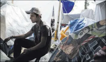  ??  ?? Eduardo Favela Castellano­s, homeless after his apartment complex suffered structural damage during the Sept. 19 earthquake in Mexico City, outside of his tent Friday.