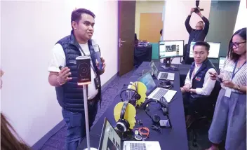  ?? SUNSTAR FOTO / ALEX BADAYOS ?? INCLUSIVE.
An Accenture official shows some of their equipment for PWDs, including a special headset for the hearingimp­aired.