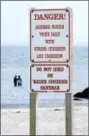  ?? ARNOLD GOLD / HEARST CONNECTICU­T MEDIA ?? Signs posted at Silver Sands State Park in Milford warn of the danger of crossing the sandbar to Charles Island.