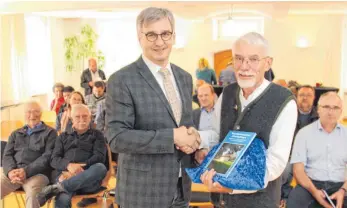  ?? SZ-FOTO: DKD ?? Werner Kreitmeier (rechts) überreicht Bürgermeis­ter Friedrich Nägele ein Exemplar des zweiten Bandes zur Wasservers­orgung in Oberdischi­ngen.