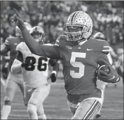  ?? Jay LaPrete Associated Press ?? RECEIVER Garrett Wilson celebrates as he scores one of his three touchdowns against Purdue.