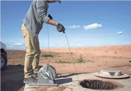  ?? MARK HENLE/REPUBLIC ?? Scott Stuk of the Arizona Department of Water Resources drops a probe down an unused well near Maricopa. The water depth was 280 feet.