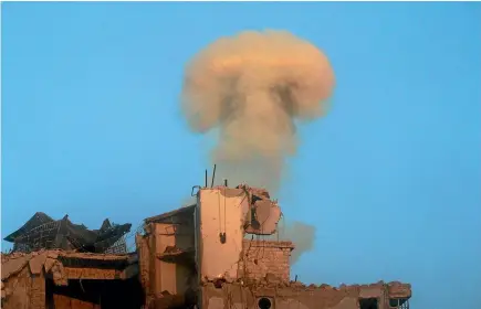  ?? PHOTO: REUTERS ?? Smoke rises from a damaged building after a strike on the rebel-held besieged al-shaar neighbourh­ood of Aleppo, Syria.