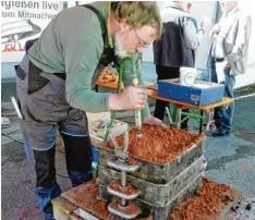  ??  ?? Der klebrige rote Sand wird mit einem Pressluft Stampfer in fünf Schichten (eine ist 30 Kilogramm schwer) in Form gepresst.