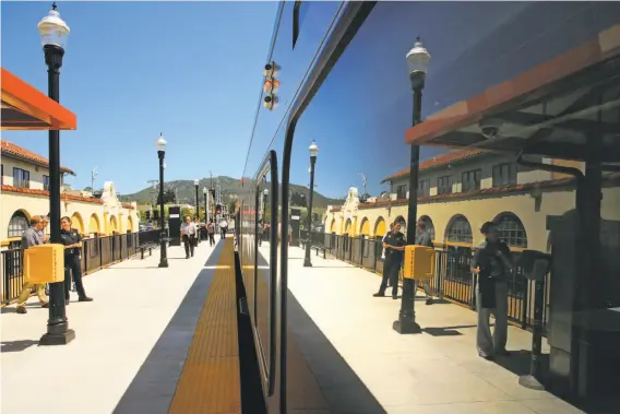  ?? Photos by Michael Macor / The Chronicle ?? The San Rafael train station is reflected in the SMART train as it makes a stop during a demonstrat­ion run of the 43-mile trip from the Petaluma station.