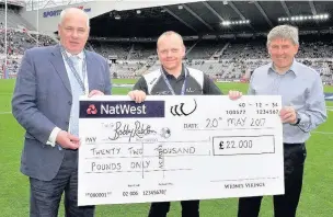  ??  ?? Widnes Vikings director Brian O’Connor hands over a cheque to the Sir Bobby Robson Foundation flanked by Sir Bobby’s son Andrew Johnson (left) and Vikings Ambassador and former footballer Peter Beardsley