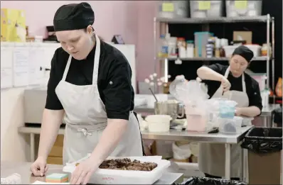  ?? PHOTOS BY MADELEINE HORDINSKI — THE NEW YORK TIMES ?? Two chefs prepare Cookie Monster Cupcakes at the Cheesecake­ry in Cincinnati on Oct. 13. With a 2021loan backed by the Small Business Administra­tion, owner Liz Field bought a building to use as a commissary kitchen, but inceasing payments have hurt.