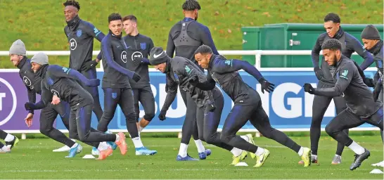  ?? (AFP) ?? England’s midfielder Raheem Sterling (second from left) and England's defender Joe Gomez (second from right) attend an England team training session