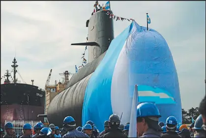  ?? AFP/ EITAN ABRAMOVICH ?? Workers stand around the ARA San Juan submarine during a ceremony celebratin­g the first stage of major repairs at the Argentine Industrial Naval Complex (CINAR) in Buenos Aires in November 2011.