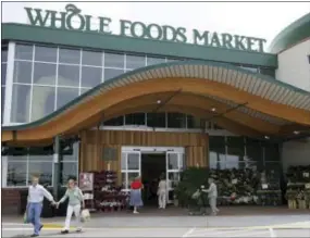  ?? THE ASSOCIATED PRESS ?? Customers are seen outside a Whole Foods Market in Dallas.